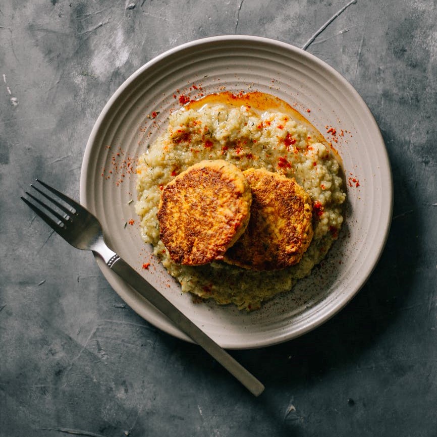 2 large fritters on a bed of mashed potatoes