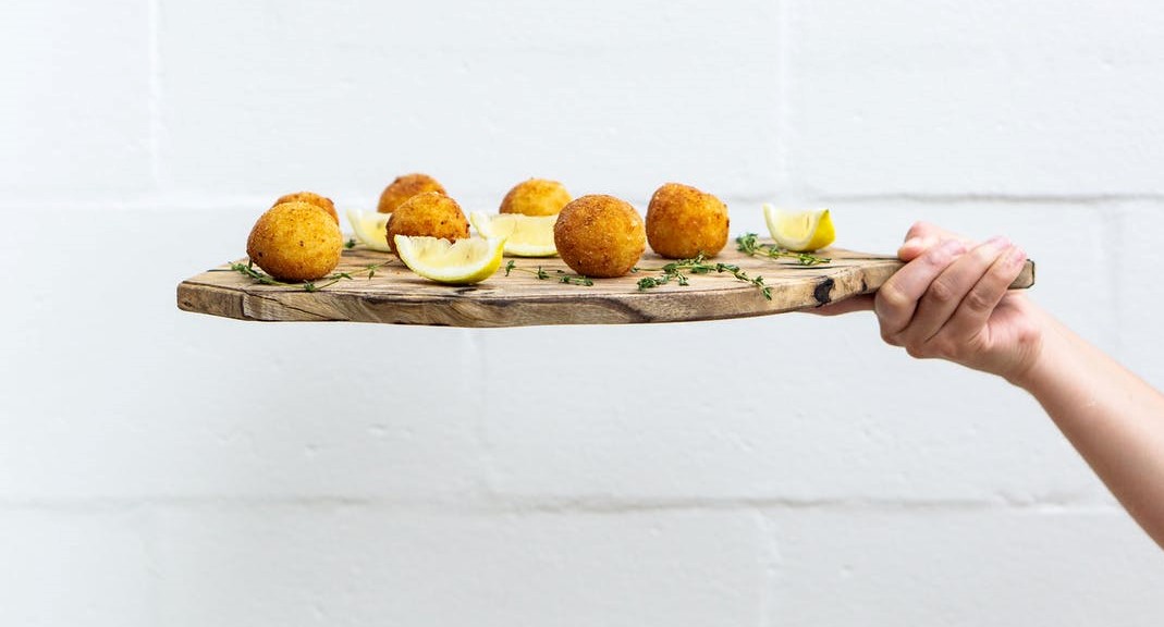 fritters and lemons on a wooden board